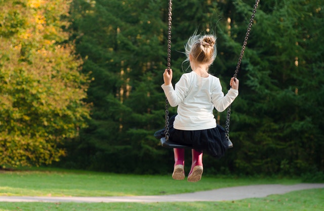 enfant se balançant dans un parc